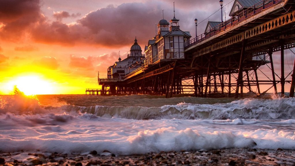 Sunrise-beach-pier-ocean-waves-buildings